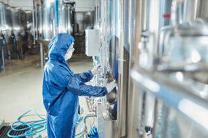 Side view portrait of woman wearing protective gear working at chemical factory