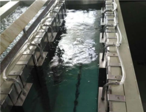 Image showing a technician handling titanium anodes in a specialized pickling tank or performing pickling in a controlled off-site environment. The image should convey a more intensive cleaning procedure with visible deposits being removed.