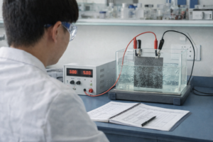An accelerated lifetime test of titanium anode plates conducted under controlled laboratory conditions, with energized electrodes, gas evolution, and real-time data recording.